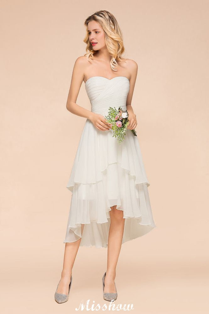 Vestido de dama de honor romántico blanco/marfil con escote corazón y corte asimétrico, sin mangas, ideal para bodas en la playa.