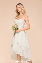 Robe de demoiselle d'honneur romantique blanche/ivoire à décolleté cœur asymétrique sans manches, idéale pour un mariage de plage.