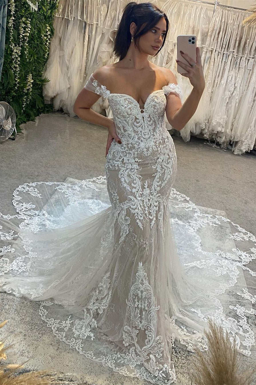 Robe de mariée sirène en dentelle, longue et sexy, décolleté cœur, épaules dénudées, sans manches, avec encolure en cœur et dentelle.