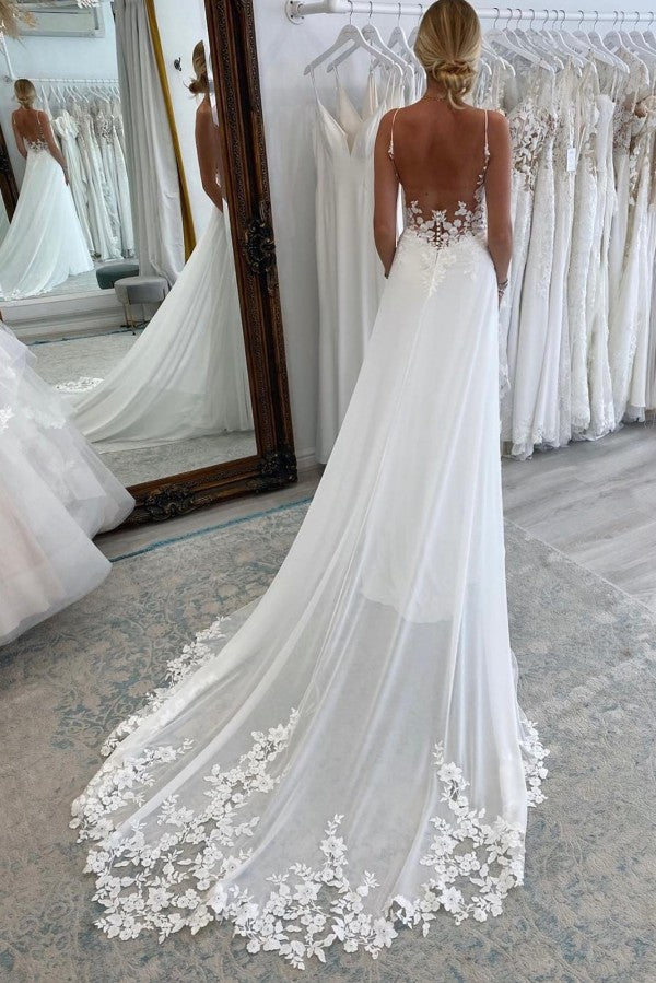 Robe de mariée longue et sexy, coupe trapèze, décolleté cœur, bretelles spaghetti, dos nu et traîne chapelle.