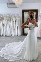 Robe de mariée longue et sexy, coupe trapèze, décolleté cœur, bretelles spaghetti, dos nu et traîne chapelle.