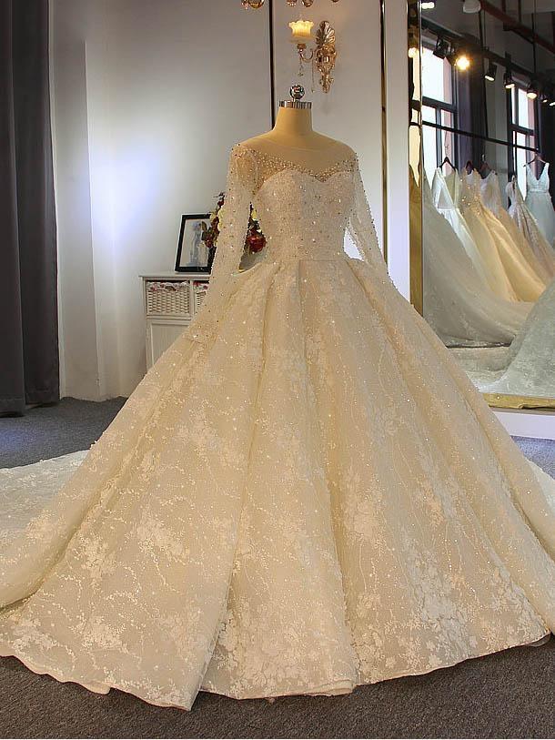 Robe de mariée longue et brillante en tulle et dentelle, décolleté cœur et manches
