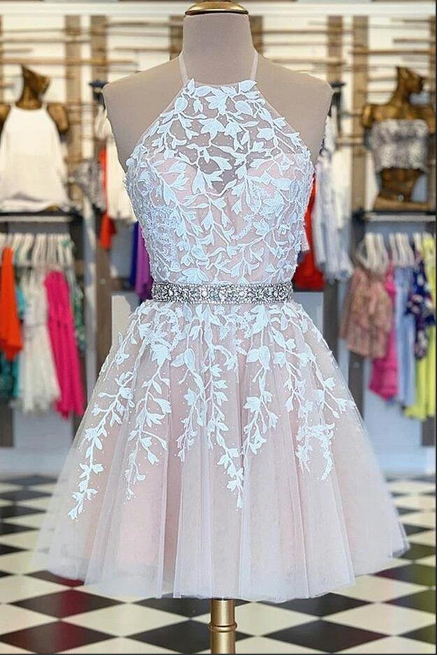Robe de bal courte trapèze en tulle et dentelle, dos nu, avec ceinture perlée.