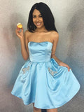 Robe de bal courte trapèze sans bretelles en satin ornée de perles et de poches