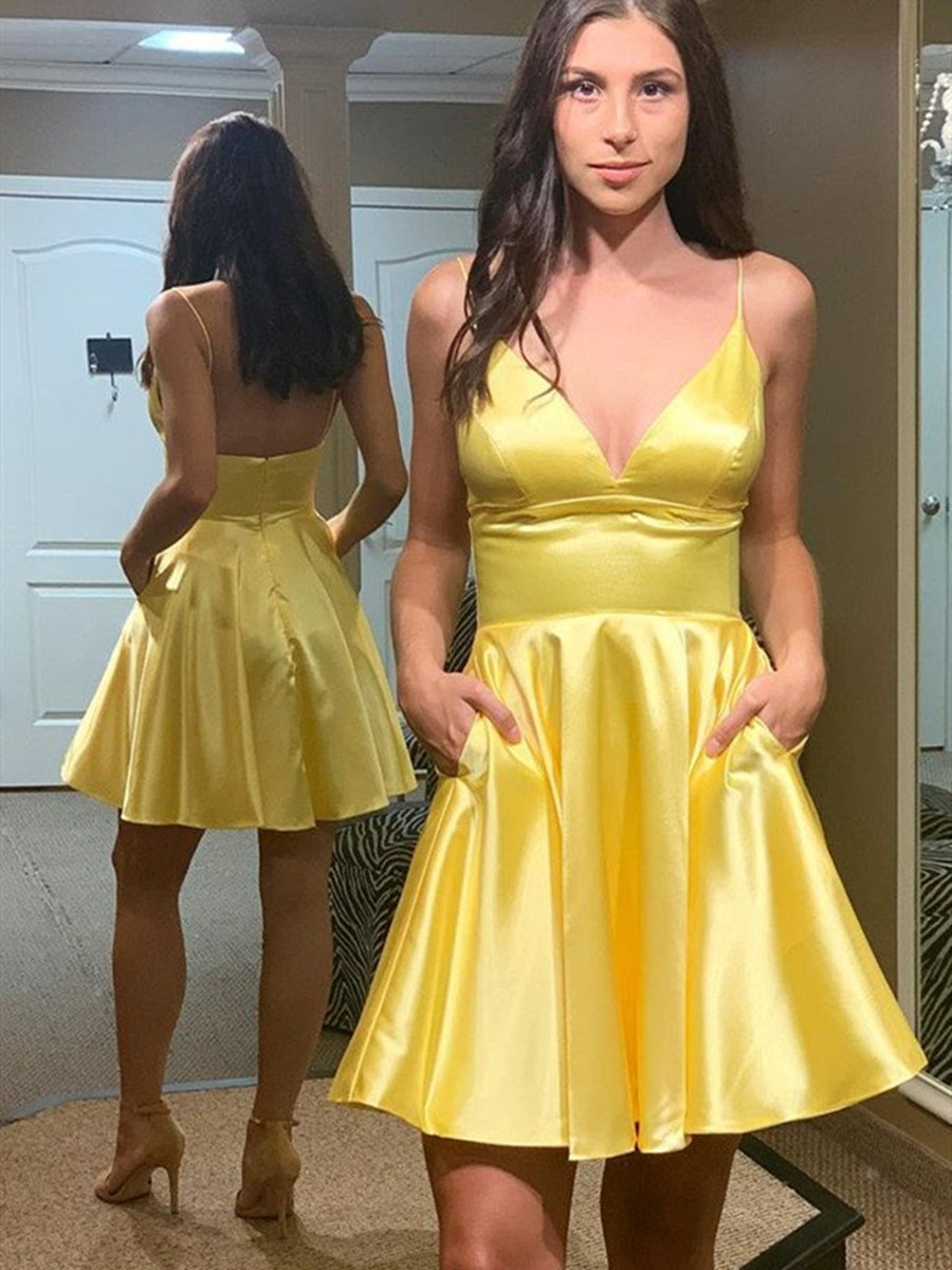 Robe de bal courte jaune satinée, coupe trapèze, col en V, dos nu et poches