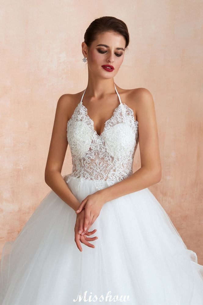 Vestido de novia sencillo de encaje con escote halter, espalda descubierta y cola de capilla.
