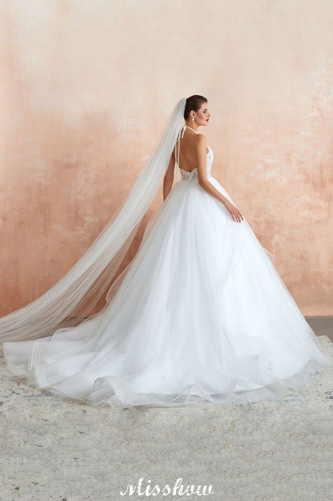 Vestido de novia sencillo de encaje con escote halter, espalda descubierta y cola de capilla.