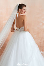 Vestido de novia sencillo de encaje con escote halter, espalda descubierta y cola de capilla.