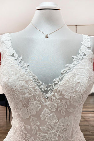 Vestido de novia sencillo, largo, de corte A, de tul, con escote en V, apliques de encaje y espalda descubierta.