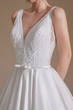 Vestido de novia sencillo, largo, de corte A, escote en V, de satén con apliques de encaje.