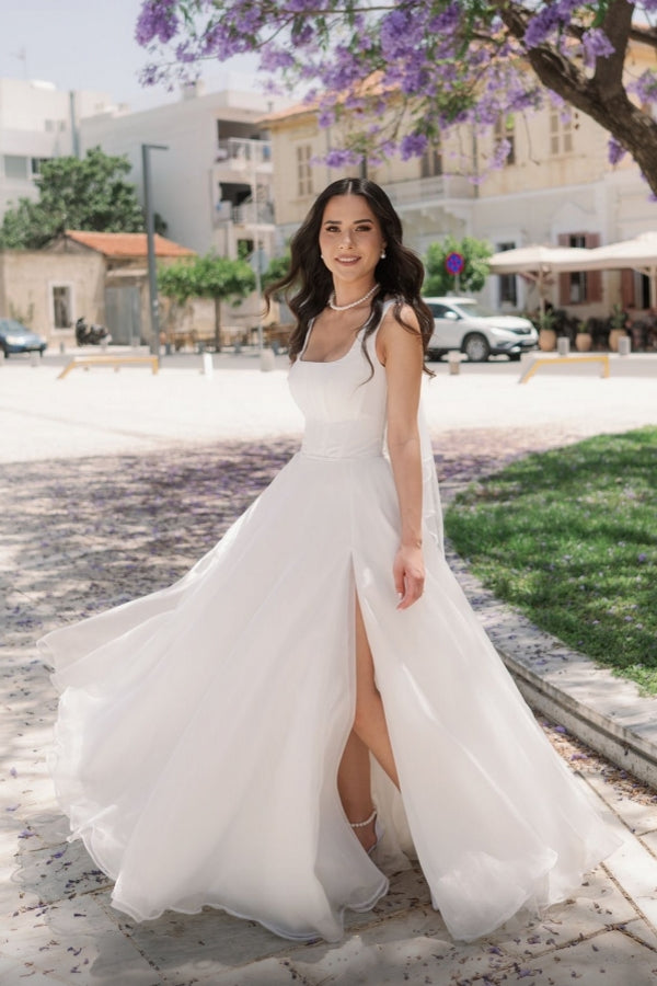 Vestido de novia sencillo, largo, color marfil, corte en A, sin mangas, de tul, con tirantes y abertura.