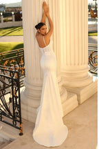 Vestido de novia de satén corte sirena, sin mangas, con tirantes finos y encaje.