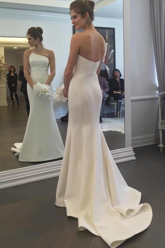Robe de mariée élégante sirène longue ivoire, simple et sans bretelles, avec traîne balayée. 