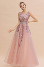 Robe de soirée longue rose poudré sans manches, coupe trapèze, ornée d'appliqués de tulle et de dentelle.