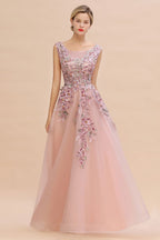 Robe de soirée longue rose poudré sans manches, coupe trapèze, ornée d'appliqués de tulle et de dentelle.