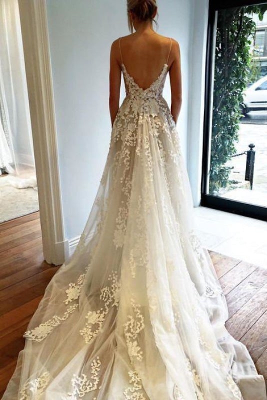 Robe de mariée élégante en tulle avec dentelle, bretelles spaghetti, décolleté en V et traîne, idéale pour la plage. 