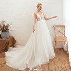 Robe de mariée champagne à fines bretelles, décolleté plongeant en V et dos nu
