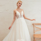 Robe de mariée champagne à fines bretelles, décolleté plongeant en V et dos nu