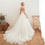 Robe de mariée champagne à fines bretelles, décolleté plongeant en V et dos nu