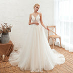 Robe de mariée champagne à fines bretelles, décolleté plongeant en V et dos nu