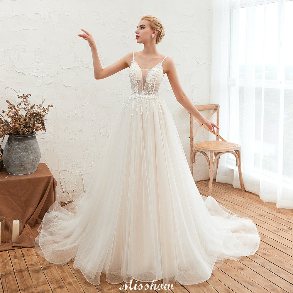 Robe de mariée champagne à fines bretelles, décolleté plongeant en V et dos nu