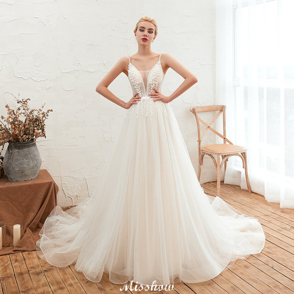 Robe de mariée champagne à fines bretelles, décolleté plongeant en V et dos nu