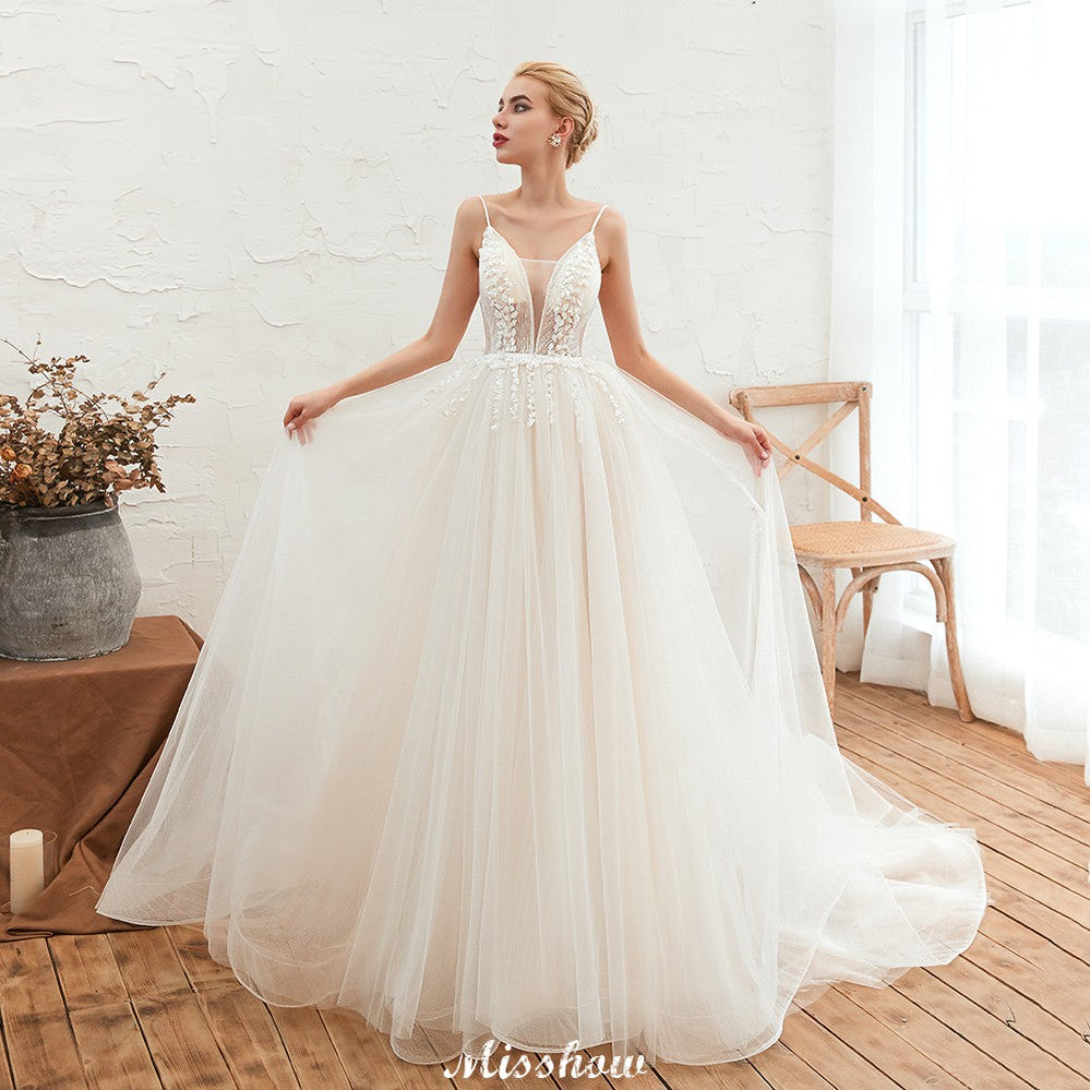Robe de mariée champagne à fines bretelles, décolleté plongeant en V et dos nu