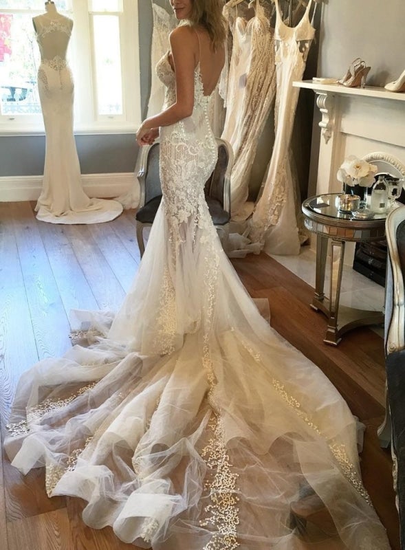 Robe de mariée élégante en tulle à fines bretelles, style sirène, décolleté en V et ornée d'appliqués. 
