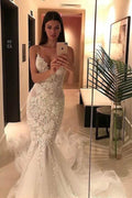 Robe de mariée élégante en tulle à fines bretelles, style sirène, décolleté en V et ornée d'appliqués. 