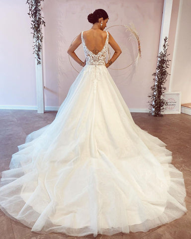 Impresionante vestido de novia largo de corte A, escote en V, espalda descubierta y apliques de encaje.
