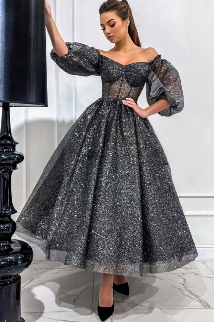 Impresionante vestido largo de fiesta gris de corte A, con hombros descubiertos, lentejuelas y mangas cortas.