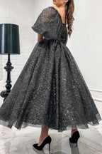 Impresionante vestido largo de fiesta gris de corte A, con hombros descubiertos, lentejuelas y mangas cortas.