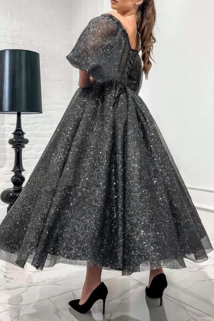 Impresionante vestido largo de fiesta gris de corte A, con hombros descubiertos, lentejuelas y mangas cortas.