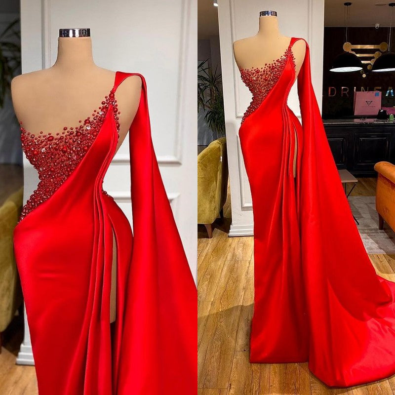 Robe de soirée sirène fendue jusqu'à la cuisse, ornée de pierres rouges et sans manches.