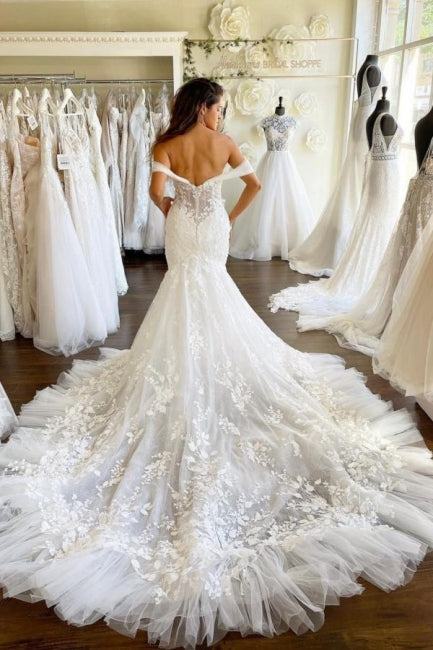 Vestido de novia corte sirena con escote corazón y hombros descubiertos, con apliques de tul y encaje.