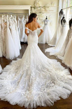 Vestido de novia corte sirena con escote corazón y hombros descubiertos, con apliques de tul y encaje.