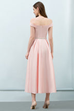Robe de bal rose mi-longue, coupe trapèze, épaules dénudées et ceinture.