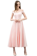 Robe de bal rose mi-longue, coupe trapèze, épaules dénudées et ceinture.