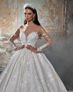 Robe de mariée tendance en dentelle, coupe trapèze, col en V, manches longues et appliques, longueur au sol.