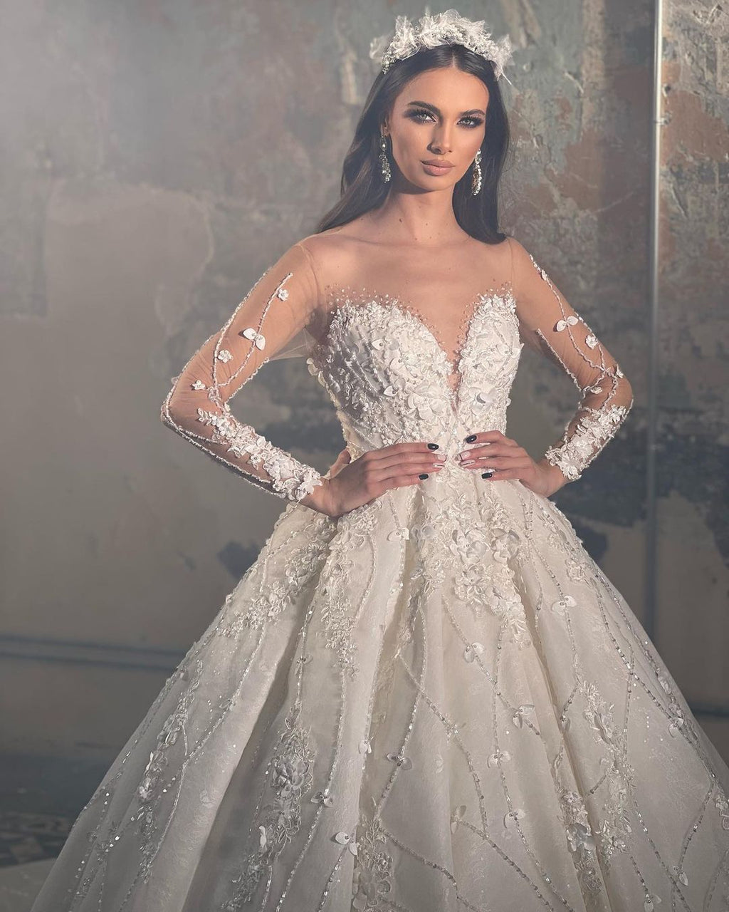 Robe de mariée tendance en dentelle, coupe trapèze, col en V, manches longues et appliques, longueur au sol.