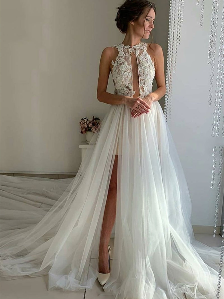 Robe de mariée longue unique en tulle et dentelle, coupe trapèze, col montant et fente.