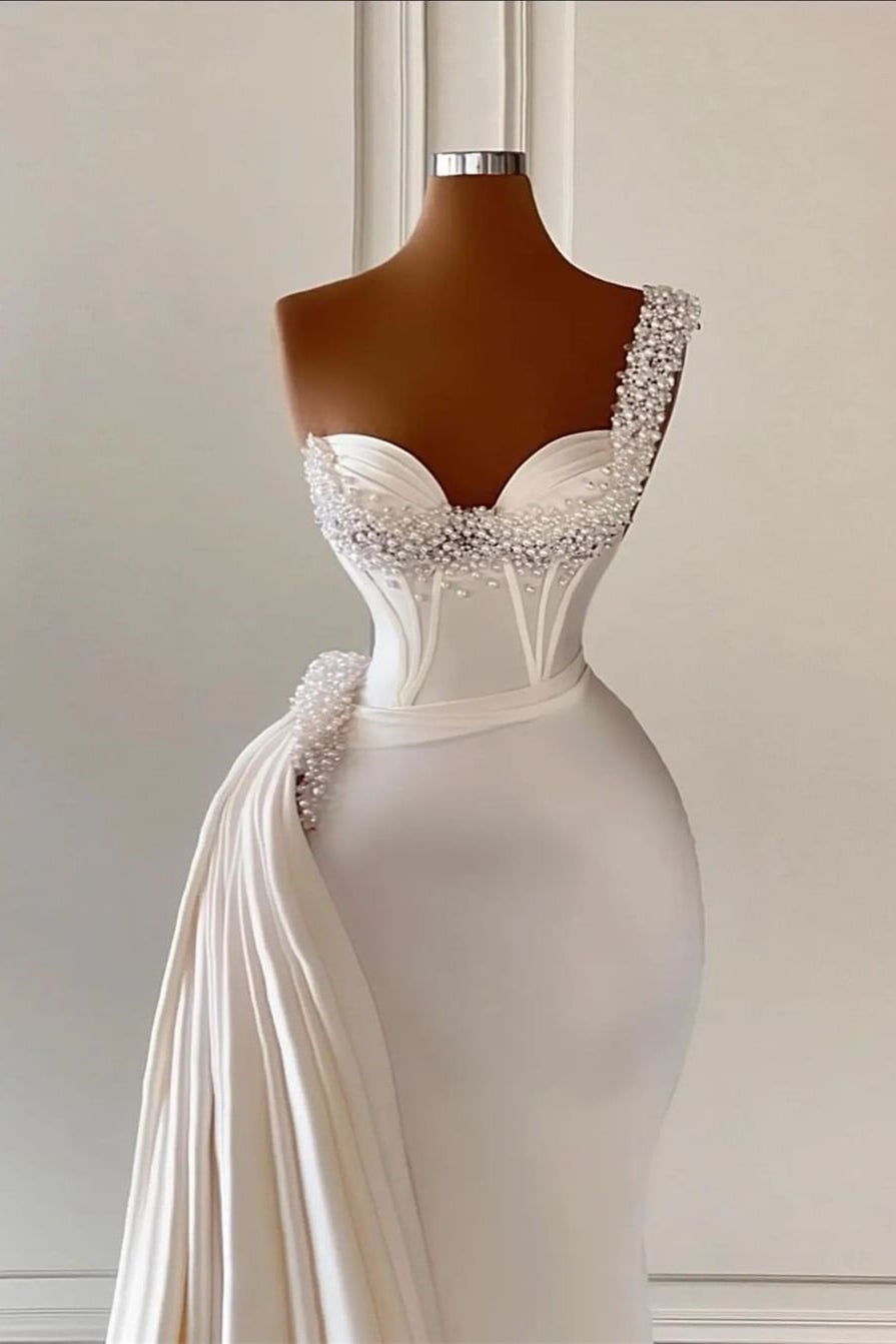 Robe de mariée unique ivoire à une épaule, décolleté cœur, sans manches, coupe trapèze, ornée de perles