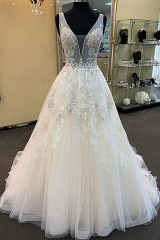 Robe de mariée unique longue en tulle et dentelle perlée, col en V, coupe trapèze.