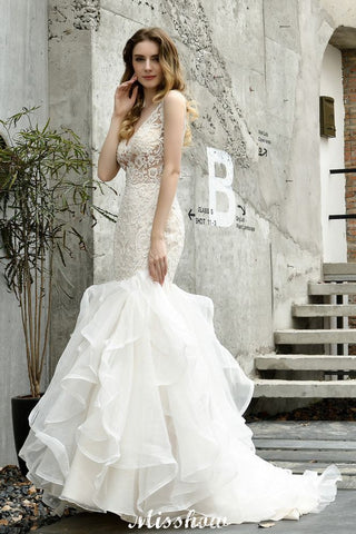 Vestido de novia de sirena sin mangas con escote en V, encaje floral y tul vaporoso.