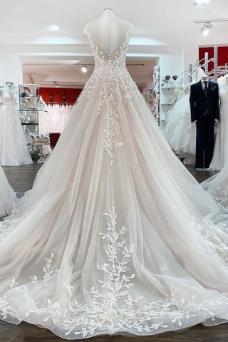 Robe de mariée vintage longue en tulle à volants et appliques de dentelle, coupe trapèze.