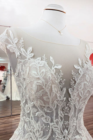 Robe de mariée vintage longue en tulle à volants et appliques de dentelle, coupe trapèze.