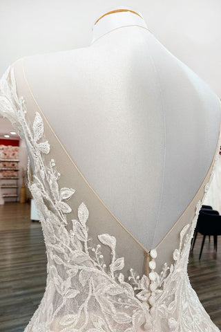 Robe de mariée vintage longue en tulle à volants et appliques de dentelle, coupe trapèze.