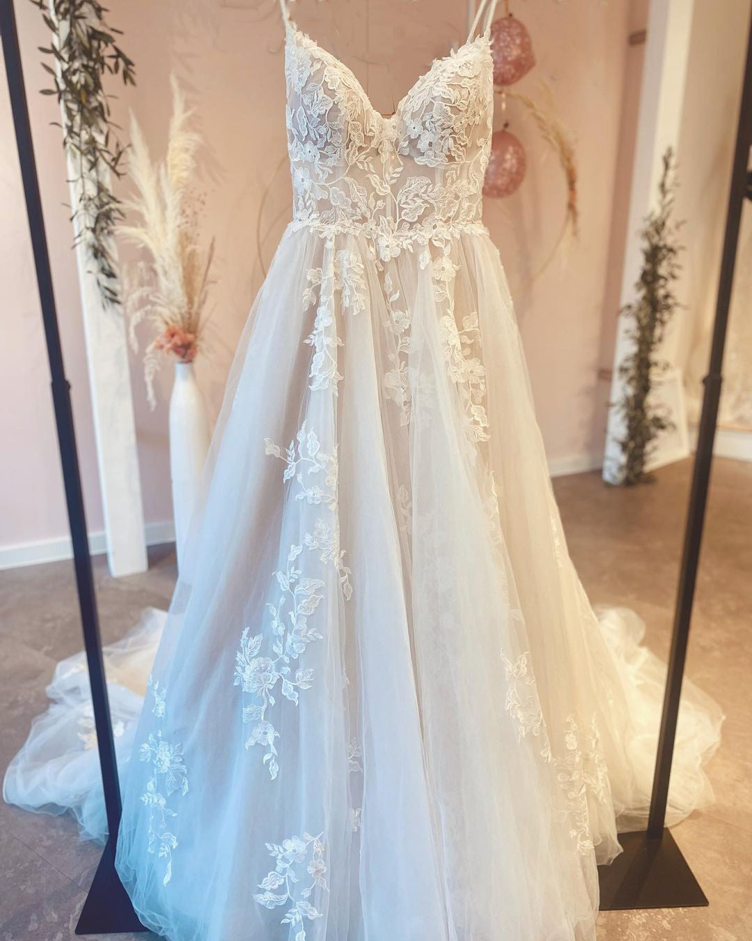 Robe de mariée vintage longue trapèze à fines bretelles, ornée d'appliqués de dentelle et d'une traîne.