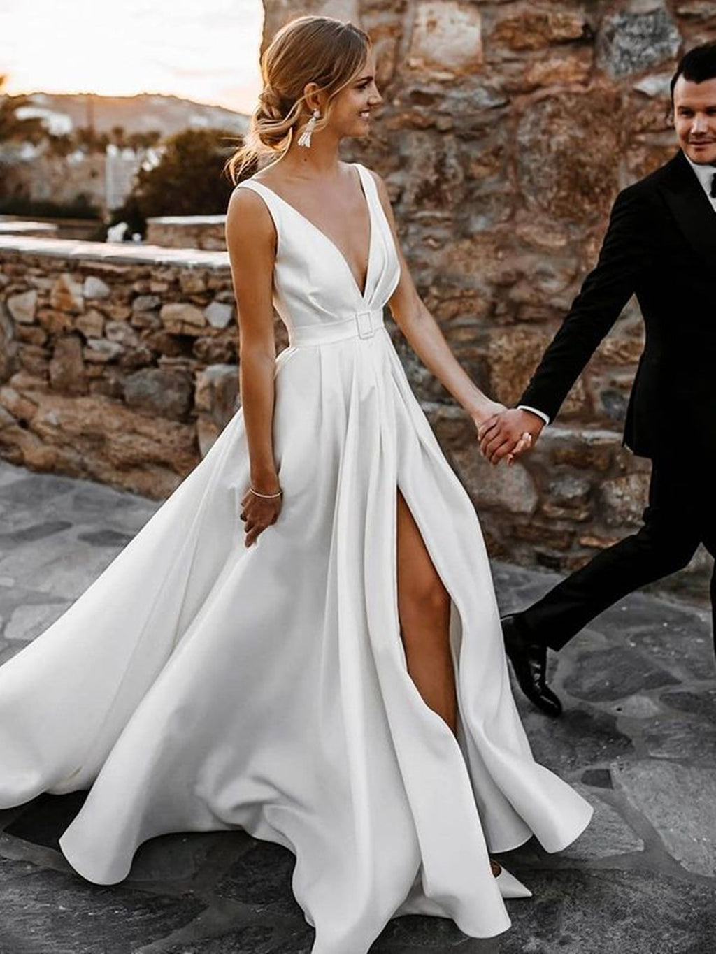 Robe de mariée blanche longue en satin, coupe trapèze, col en V, dos nu et fente.