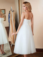 Robe de mariée blanche courte en tulle, coupe trapèze, décolleté cœur, longueur thé